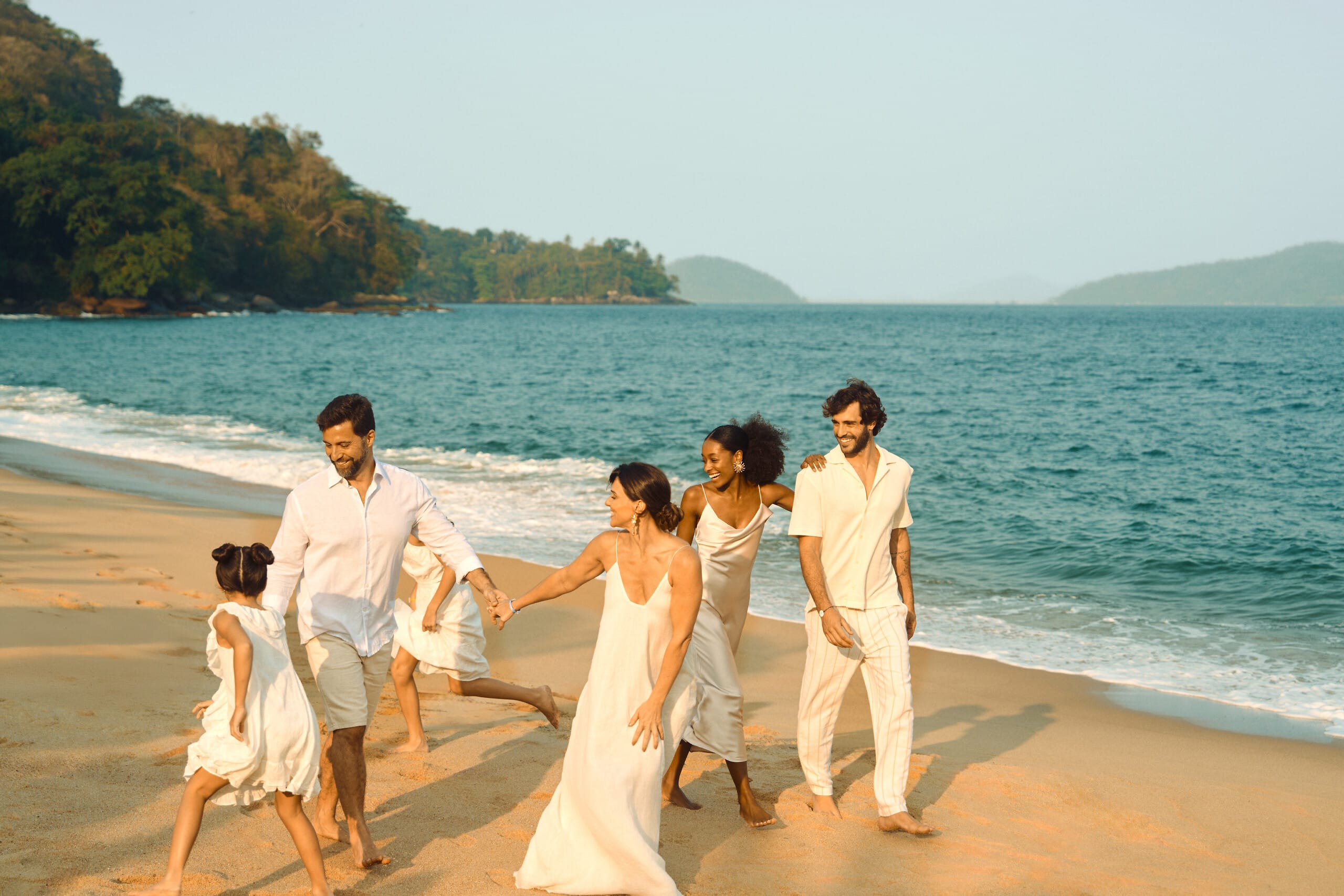 Família caminhando na praia em resort Club Med no Brasil
